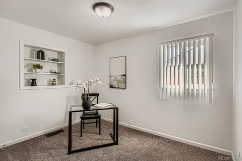 a workspace room with furniture and window