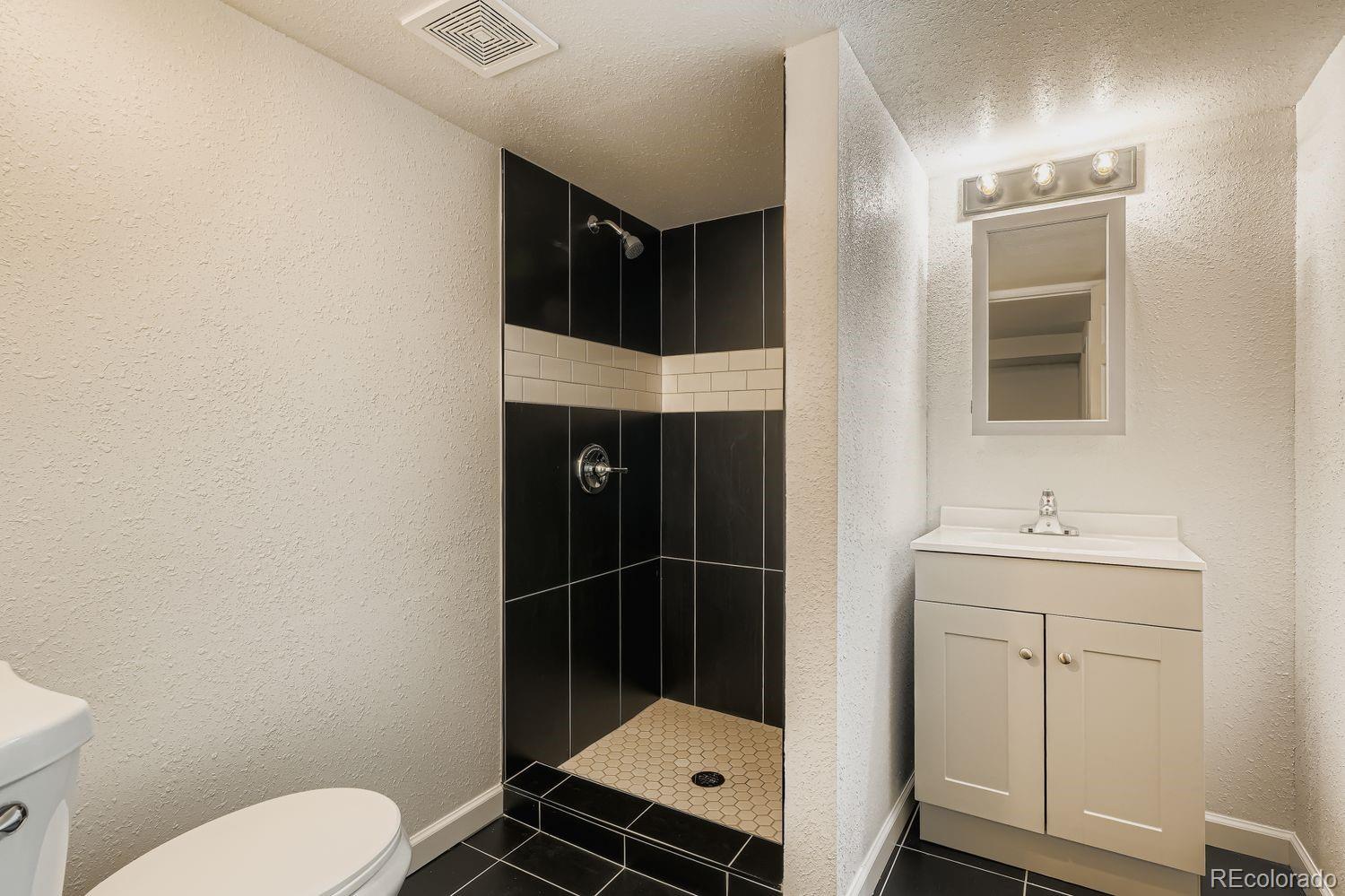 3670 Magnolia Street Denver, CO 80207 - Photo 18 of 26 a bathroom with a toilet a sink and mirror