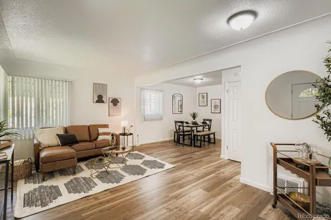a living room with furniture and a wooden floor
