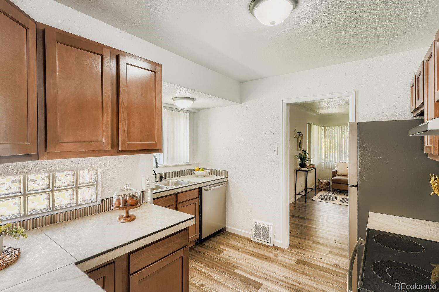 3670 Magnolia Street Denver, CO 80207 - Photo 3 of 26 a kitchen with a sink cabinets and wooden floor