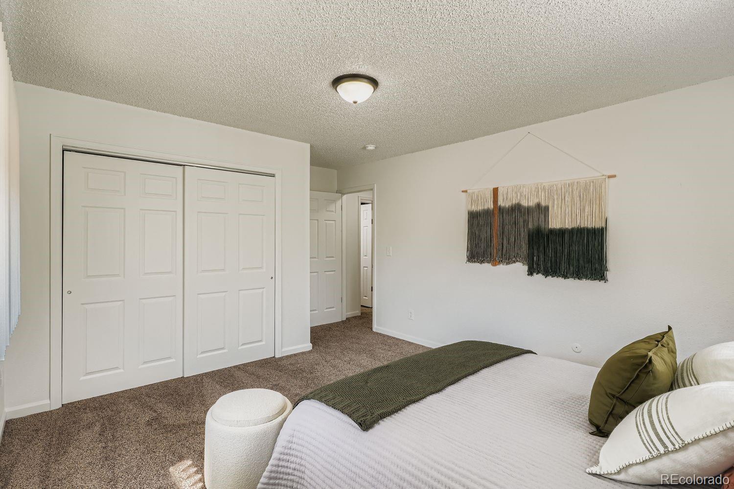 3670 Magnolia Street Denver, CO 80207 - Photo 10 of 26 a bedroom with a bed and a couch