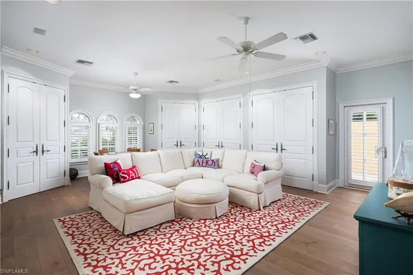 a living room with furniture kitchen view and a flat screen tv