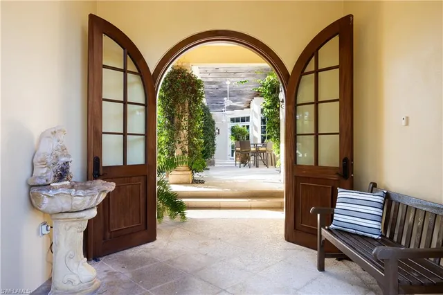a view of a patio with table and chairs potted plants and a large tree