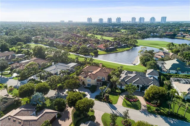 an aerial view of a house with a yard and lake view in back