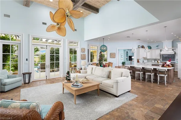 a living room with furniture a chandelier and a large window