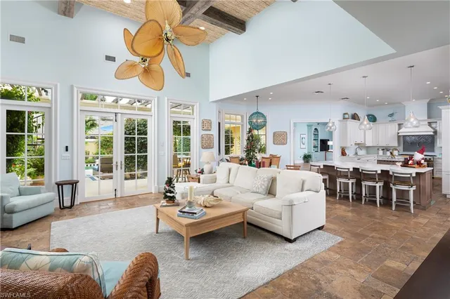 a living room with furniture a chandelier and a large window