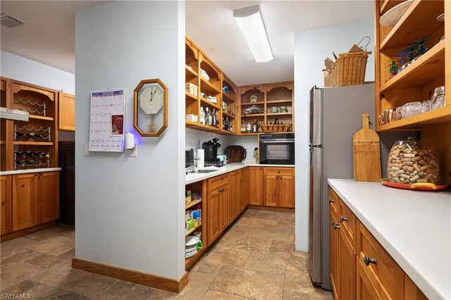 a utility room with stainless steel appliances cabinets and a large window