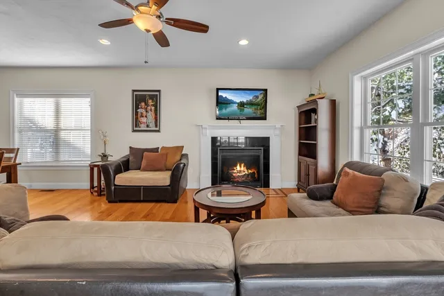 a living room with furniture a large window and a fireplace