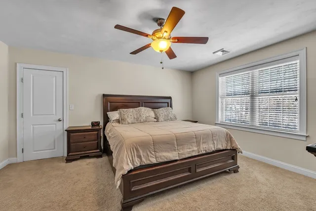 a bedroom with a bed and a large window