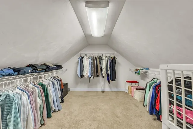 a view of walk in closet with clothes and shoes