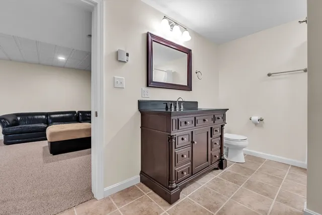 a spacious bathroom with a toilet sink and mirror