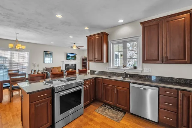 a kitchen with stainless steel appliances granite countertop a sink stove and cabinets