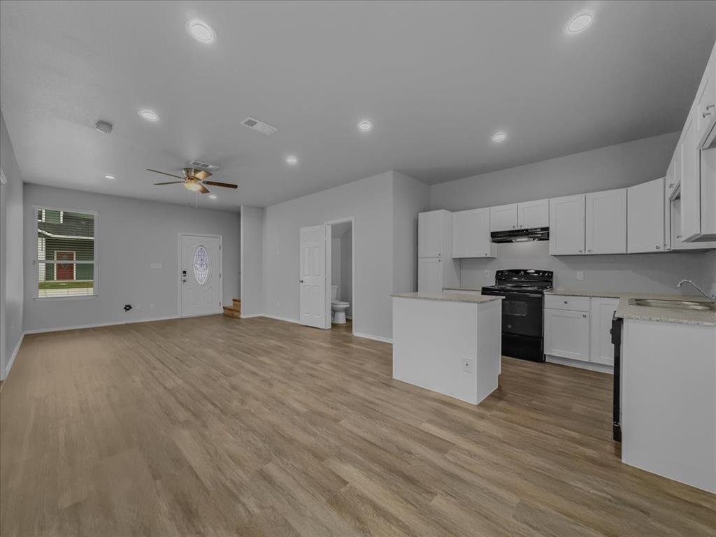 a view of kitchen with wooden floor and electronic appliances