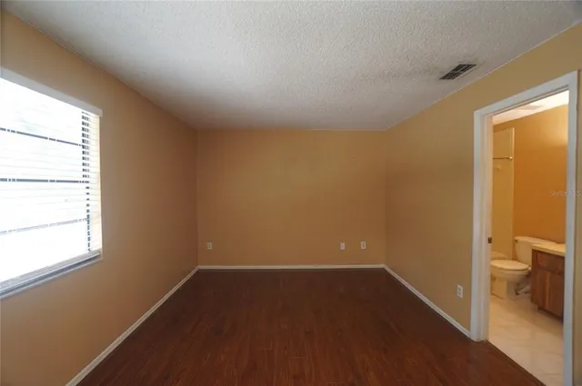 a view of a room with wooden floor and a window