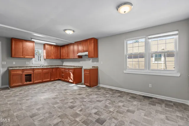 a large kitchen with stainless steel appliances granite countertop a stove a sink and a refrigerator