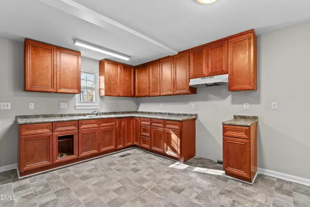 a kitchen with stainless steel appliances granite countertop wooden cabinets a stove top oven a sink and dishwasher