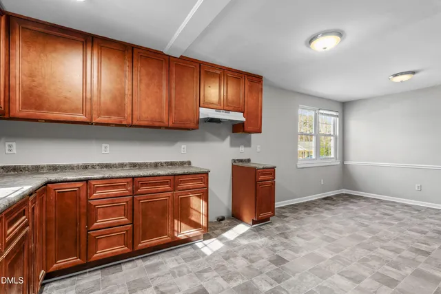 a kitchen with stainless steel appliances granite countertop wooden cabinets a sink and a window