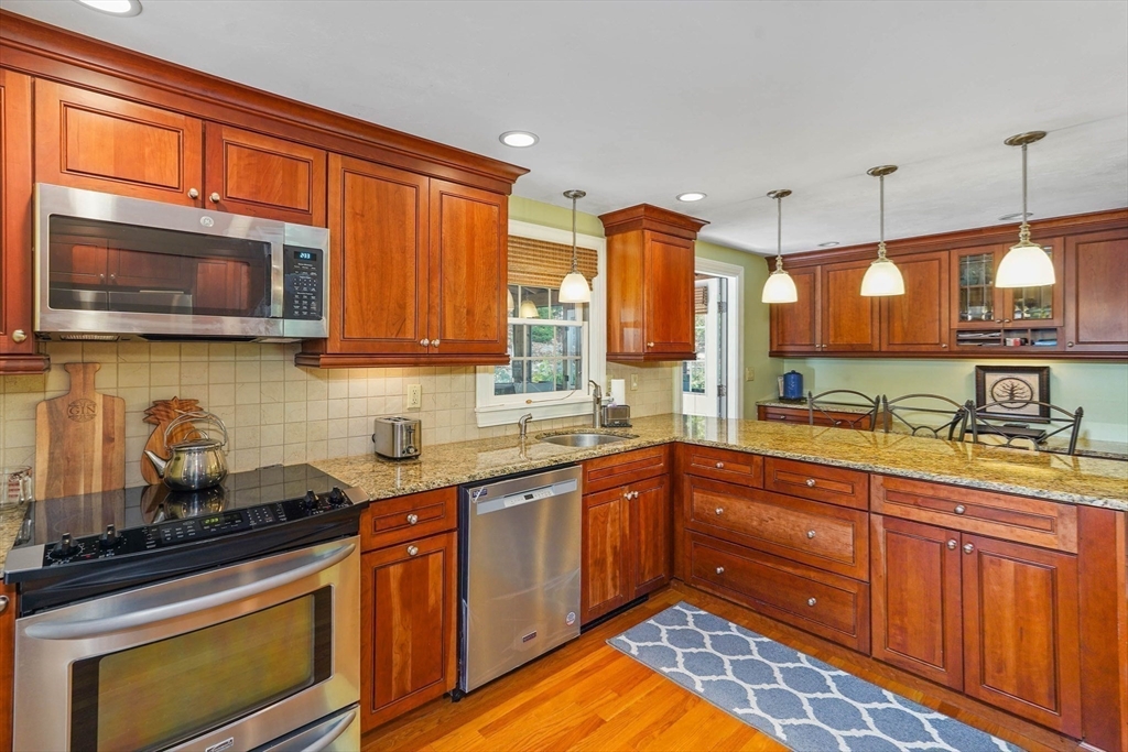 40 Breakneck Road Sturbridge, MA 01566 - Photo 9 of 39 a kitchen with stainless steel appliances granite countertop wooden cabinets and a stove top oven