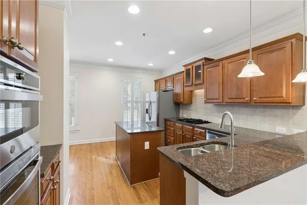 a kitchen with stainless steel appliances granite countertop a sink a oven and a microwave