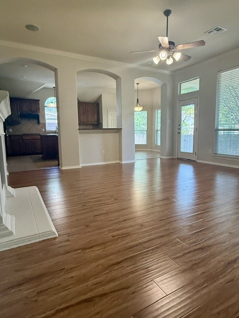 20724 Kearney Hill Road Pflugerville, TX 78660 - Photo 19 of 40 Spacious interior featuring wood-finish flooring, arched doorways, a ceiling fan with integrated lighting, and white baseboards