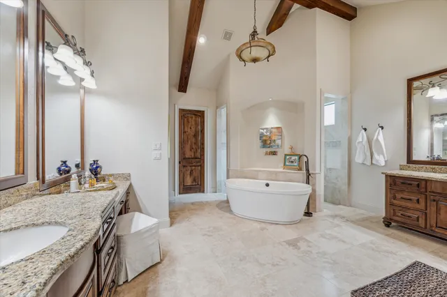 a spacious bathroom with a granite countertop sink mirror and bathtub