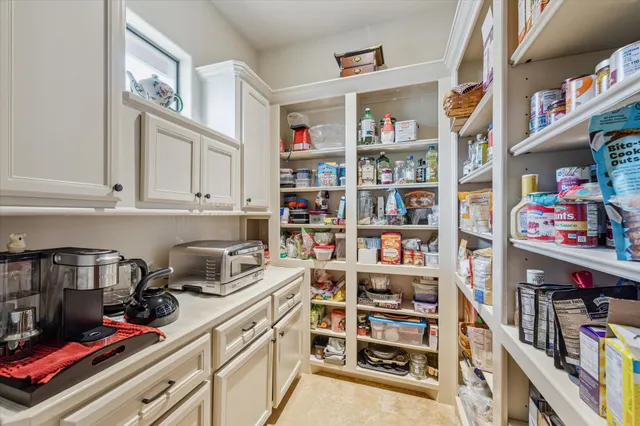 a kitchen with white cabinets and chair