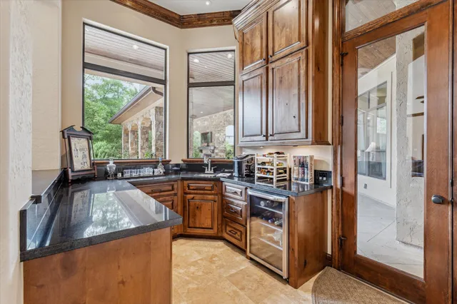 a kitchen with stainless steel appliances granite countertop a refrigerator a stove and a sink with wooden cabinets