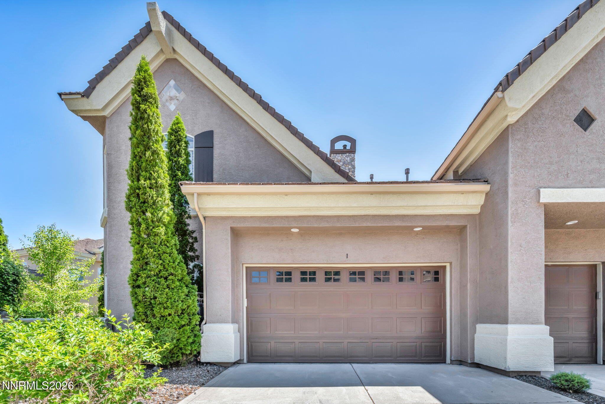 a front view of a house with plants