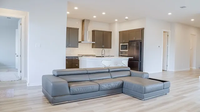 a living room with stainless steel appliances kitchen island granite countertop furniture and a couch