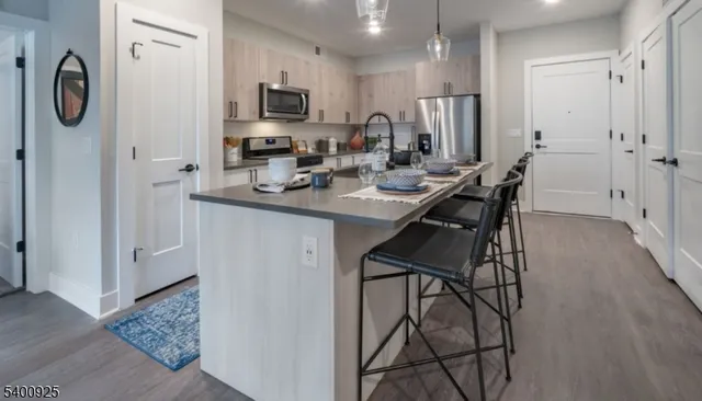 a kitchen with stainless steel appliances granite countertop a refrigerator and a stove top oven