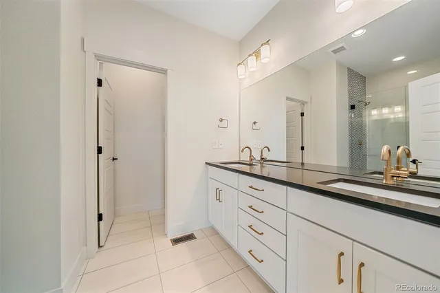 a bathroom with double sink and a mirror