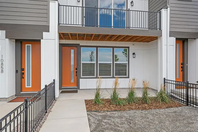 a front view of a building with a garden and plants