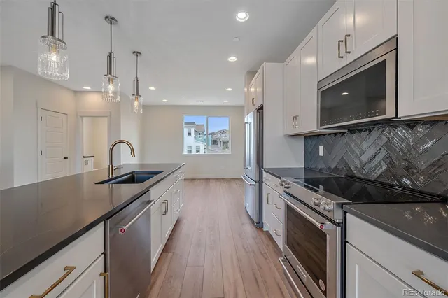 a kitchen with stainless steel appliances granite countertop a sink a stove and a microwave