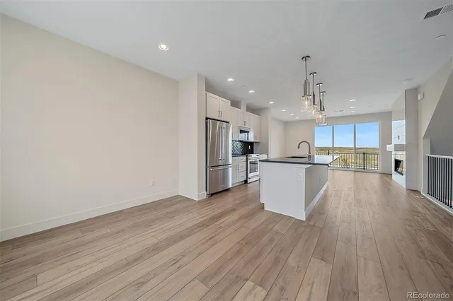 a view of kitchen with wooden floor and electronic appliances