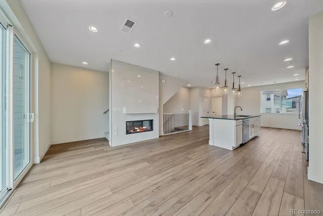 a view of a kitchen with refrigerator and wooden floor