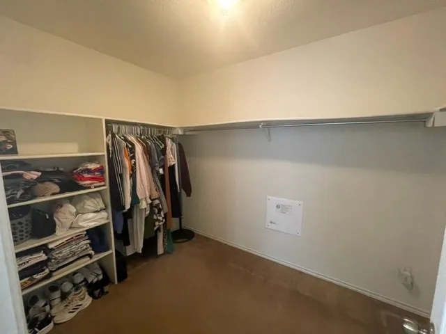 a view of walk in closet with clothes