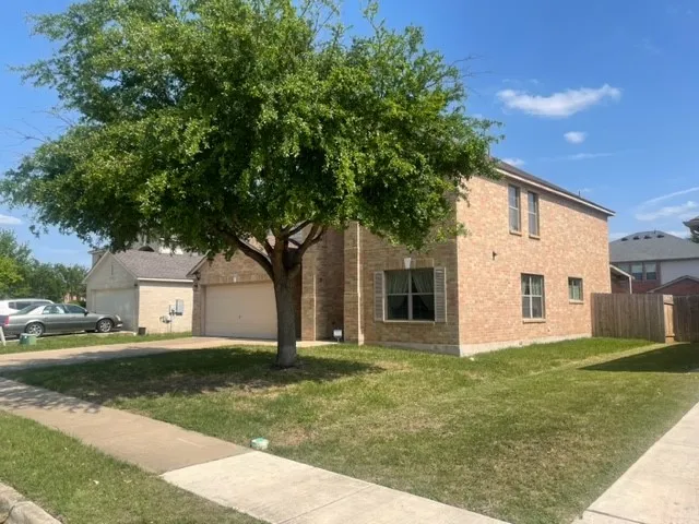 a front view of a house with a garden and trees