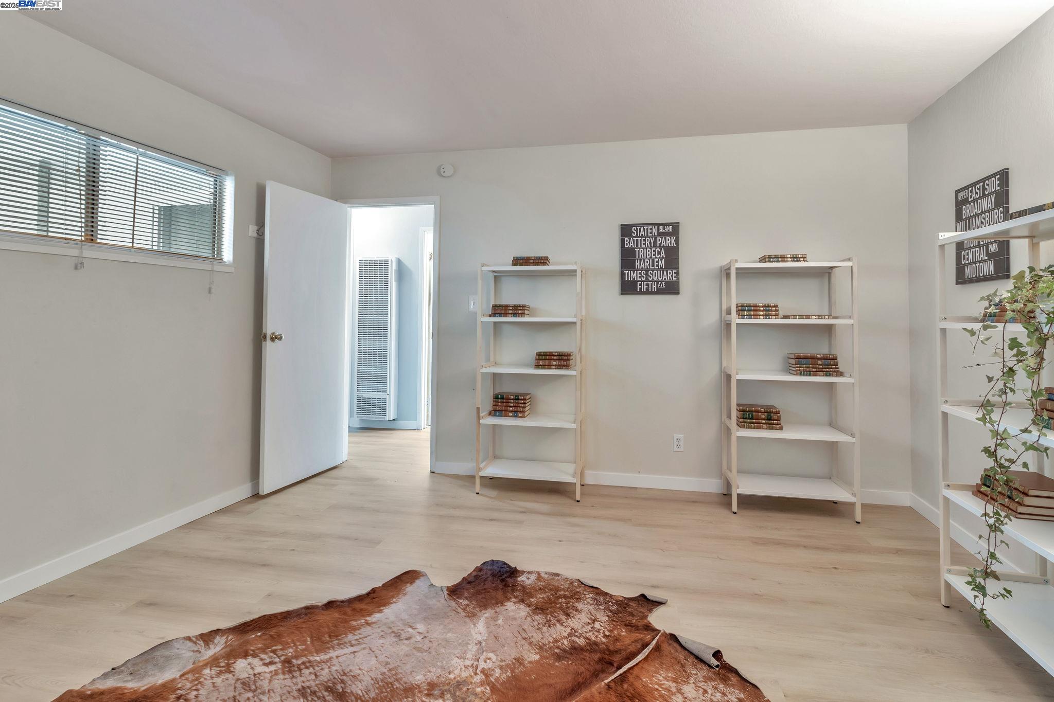 3877 Howe Street, Unit 106 Oakland, CA 94611 - Photo 11 of 17 a living room with furniture and a book shelf