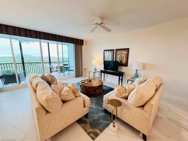 a living room with furniture and a floor to ceiling window