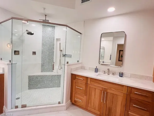 a bathroom with a double vanity sink mirror and shower