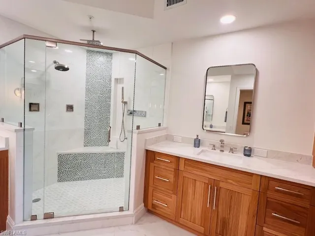 a bathroom with a double vanity sink mirror and shower