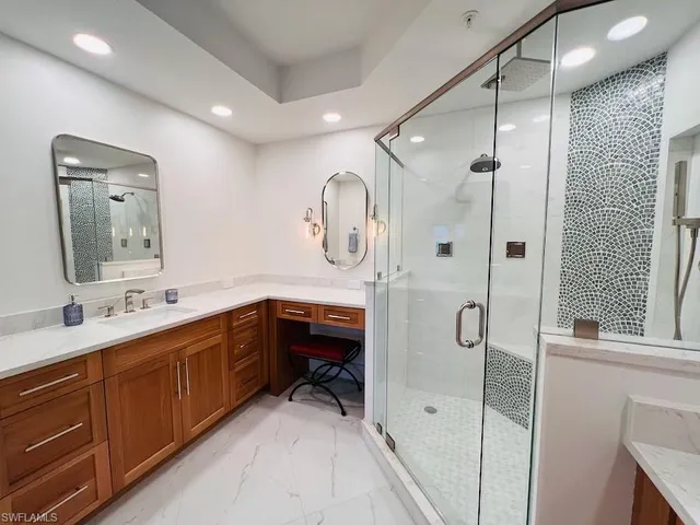 a spacious bathroom with a double vanity sink a mirror and shower