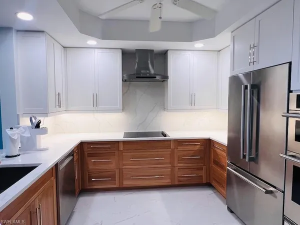 a kitchen with stainless steel appliances granite countertop a refrigerator and a sink