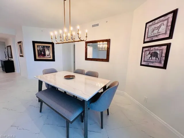 a view of a dining room with furniture and chandelier