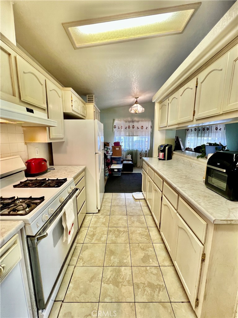9391 California Avenue, Unit 97 Riverside, CA 92503 - Photo 11 of 21 a kitchen with stainless steel appliances granite countertop a stove a sink and a refrigerator
