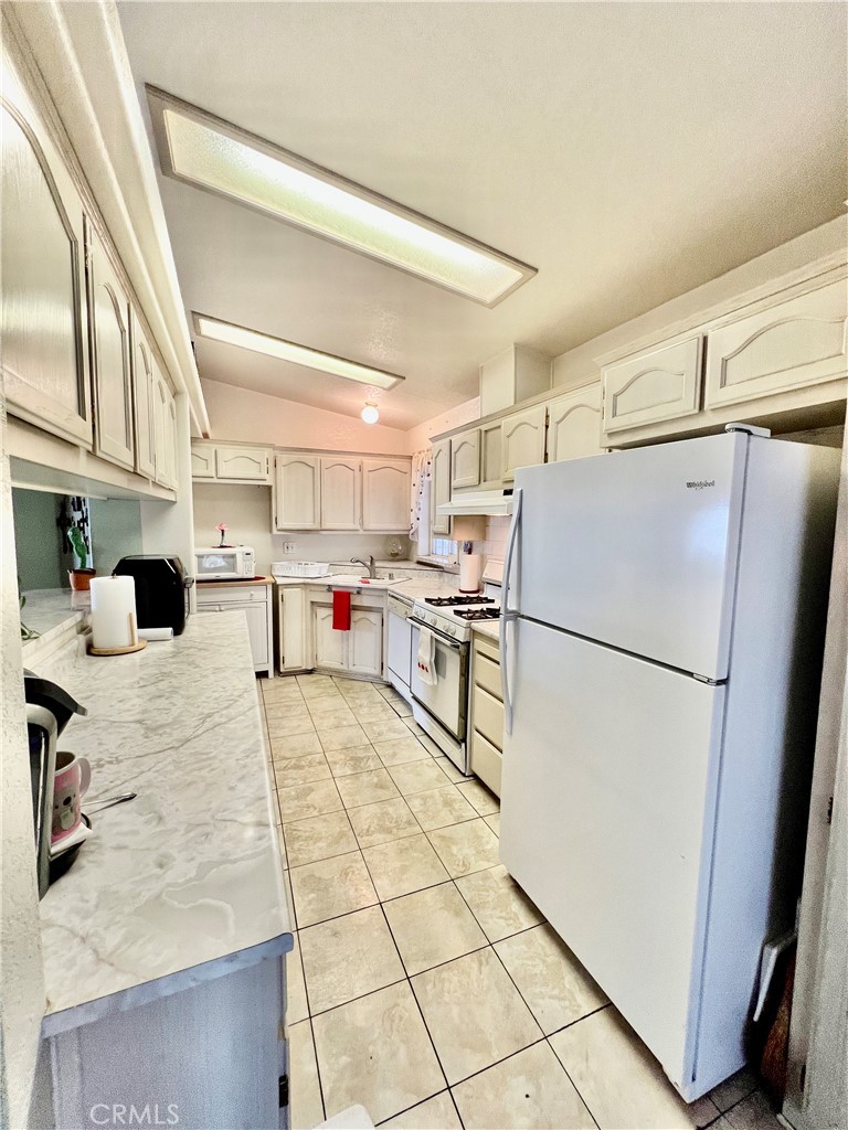 9391 California Avenue, Unit 97 Riverside, CA 92503 - Photo 12 of 21 a kitchen with stainless steel appliances a refrigerator sink and cabinets