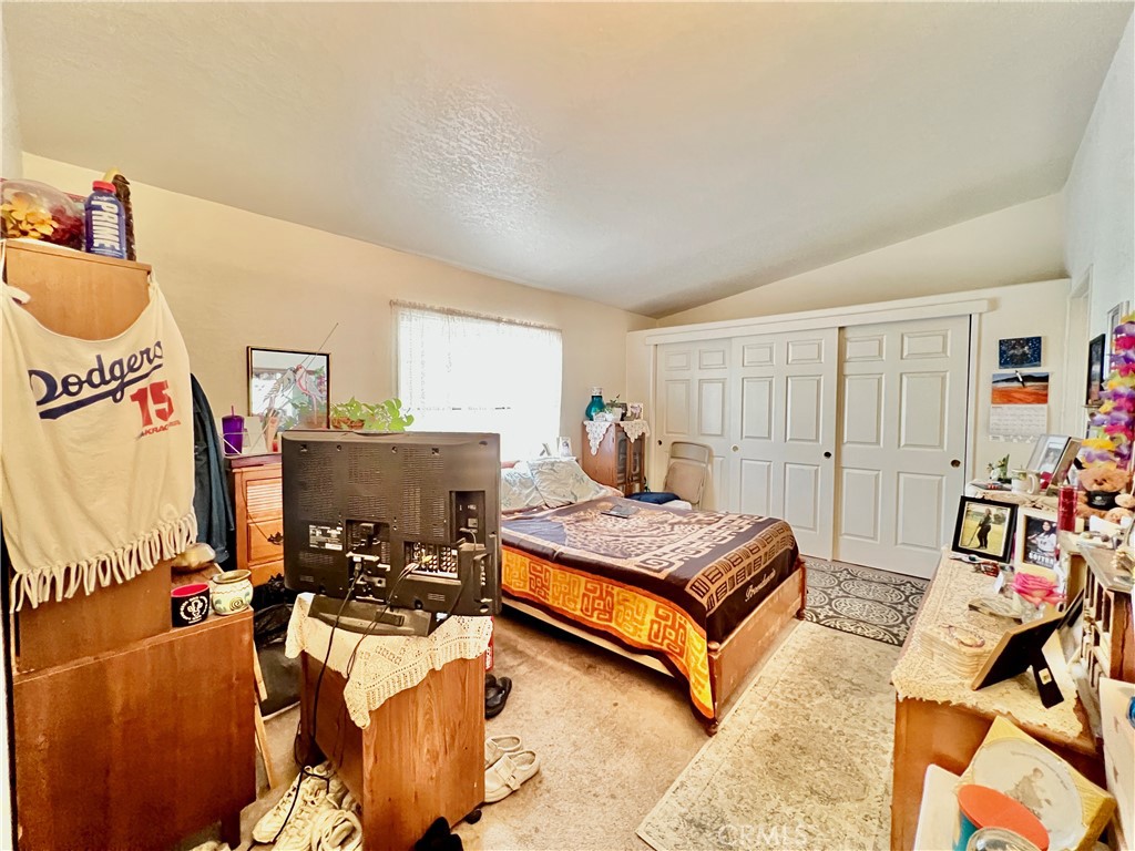 9391 California Avenue, Unit 97 Riverside, CA 92503 - Photo 18 of 21 a bedroom with a bed and a flat tv screen on the dresser