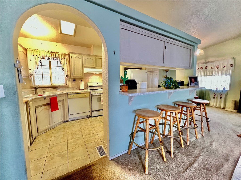 9391 California Avenue, Unit 97 Riverside, CA 92503 - Photo 8 of 21 a kitchen with stainless steel appliances kitchen island granite countertop a table and chairs in it