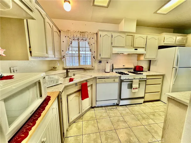a kitchen with a sink a stove and cabinets