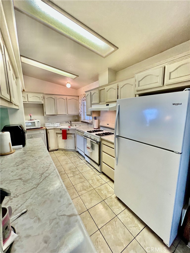 9391 California Avenue, Unit 97 Riverside, CA 92503 - Photo 10 of 21 a kitchen with refrigerator and cabinets